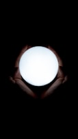 A close-up of hands gently holding a glowing orb of light, symbolizing inner energy.
