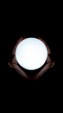 Hands gently holding a glowing orb of light symbolizing energetic balance and healing.