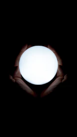 Hands gently holding a glowing orb symbolizing inner energy and transformation.