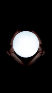 Close-up of hands holding a glowing orb symbolizing energy and balance.