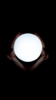 A serene setting with hands gently holding glowing energy orbs symbolizing kinesiologie and energy work.