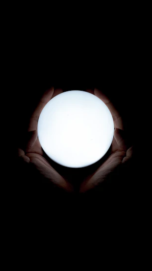 Hands gently holding a glowing orb symbolizing spiritual energy and healing.