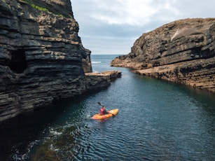 man riding kayak on body of water