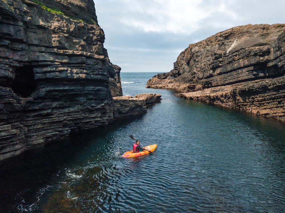 man riding kayak on body of water