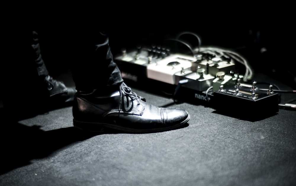 person's feet standing near effects pedals