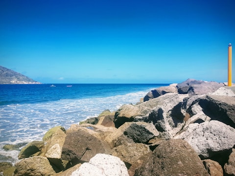 A scenic view of Qingdao’s coastline with colorful boats and clear blue water under a sunny sky