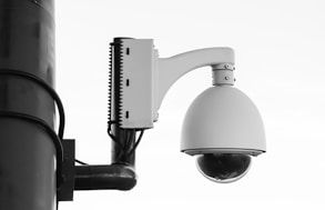white security camera on post