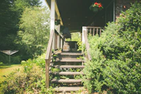 A sturdy wooden ramp leading up to a welcoming front porch surrounded by greenery.