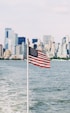 U.S.A. flag on pole near sea under cloudy sky
