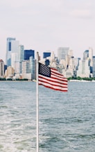 U.S.A. flag on pole near sea under cloudy sky