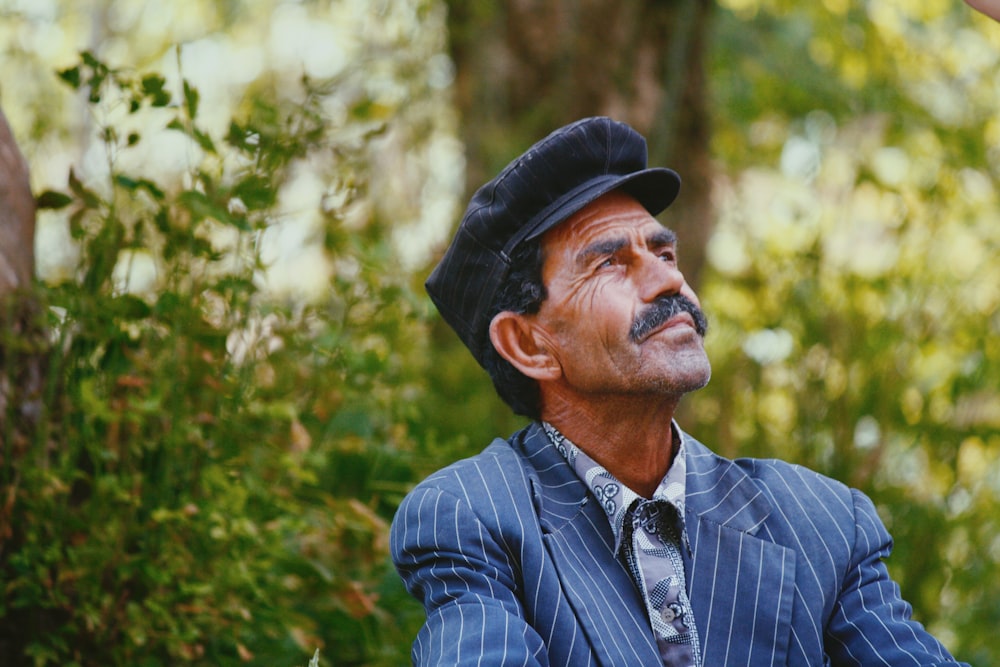 Foto selectiva de hombre con camisa azul de pie junto a un árbol