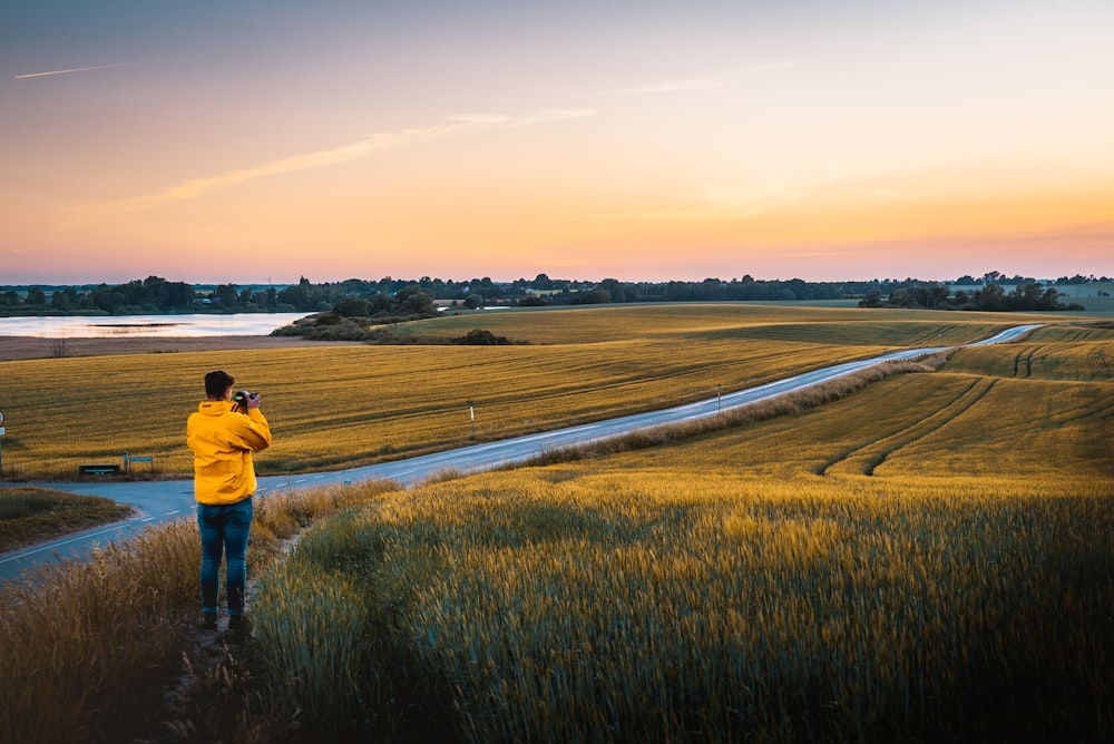 man taking photo of grassland