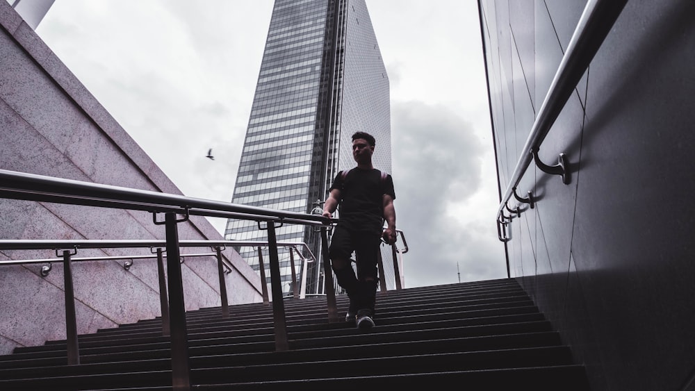 man in black shirt walking along steps during daytime