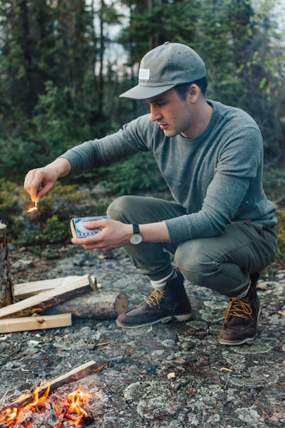 selective focus photography of man holding lit matchstick outdoors