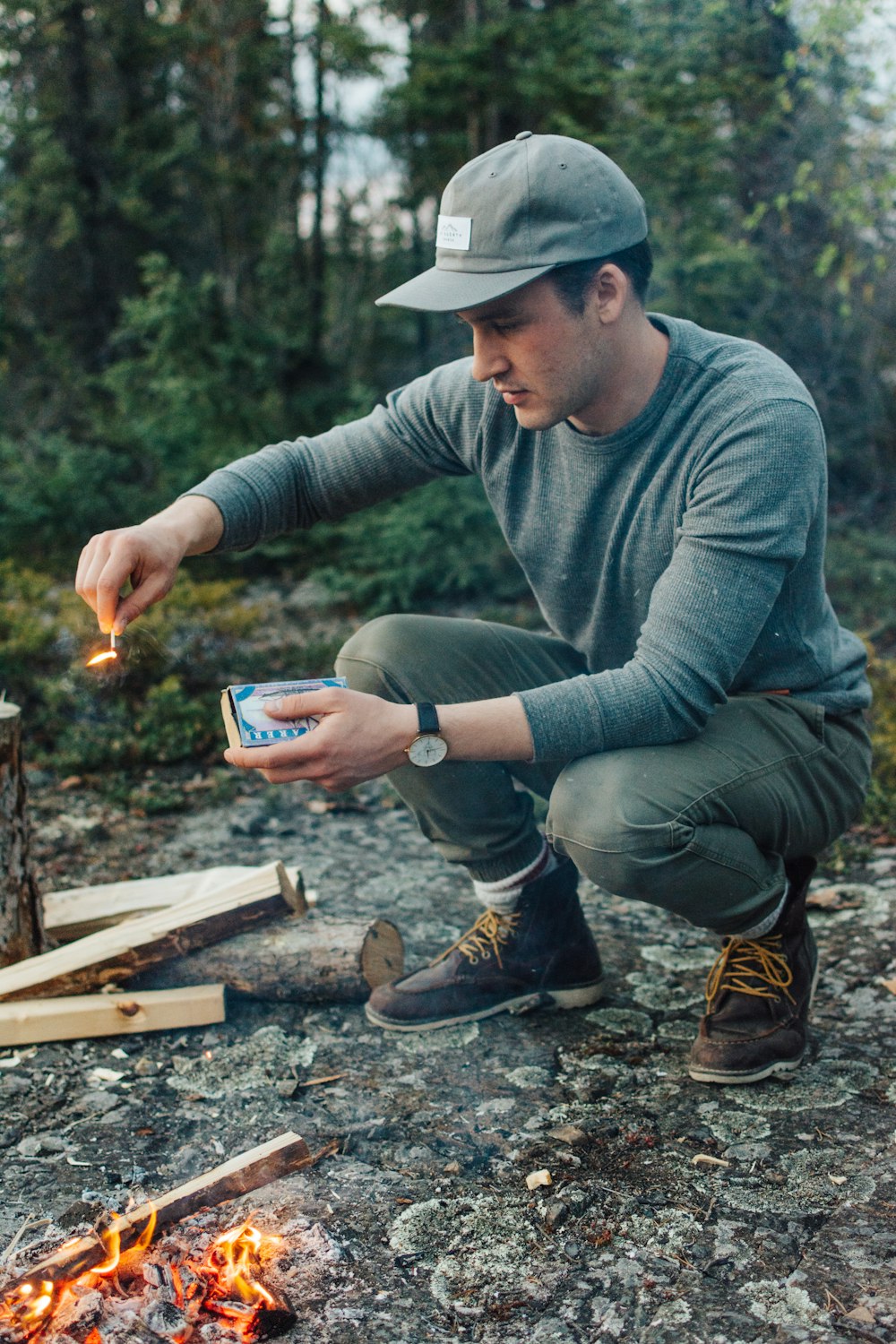 selective focus photography of man holding lit matchstick outdoors