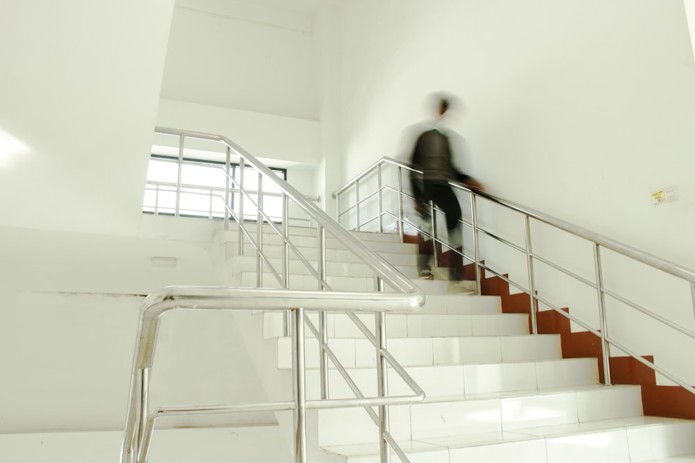 person going down white tiled stairs