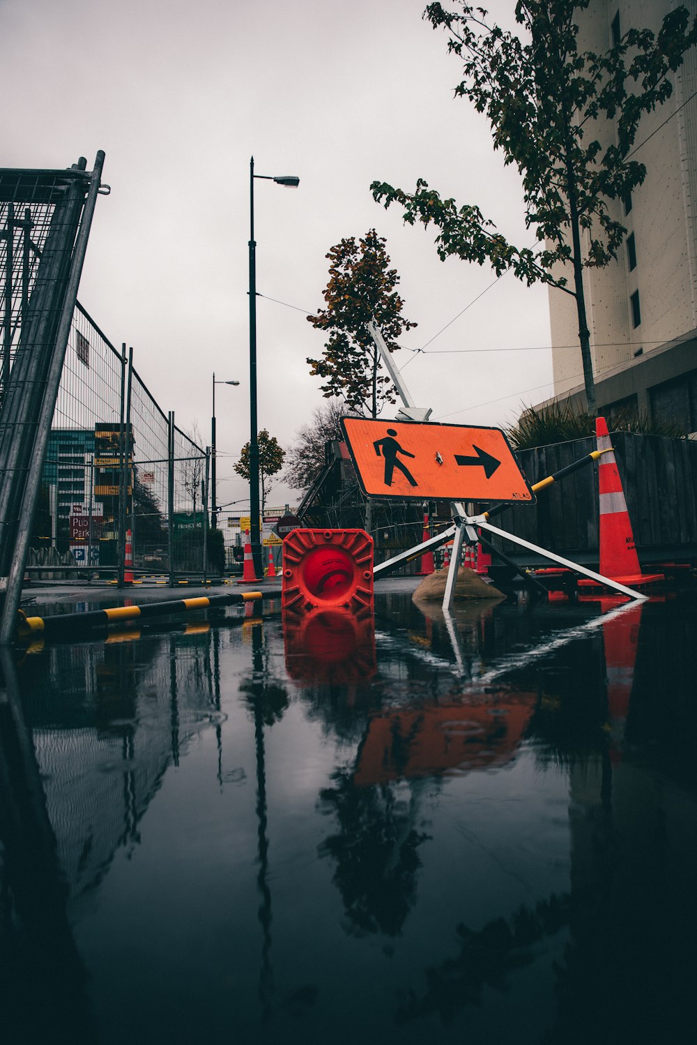 Cône de signalisation orange et blanc près du lampadaire pendant la journée