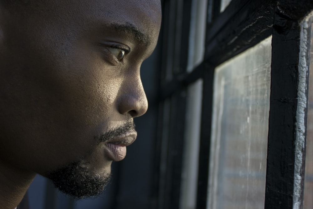 man near glass window pane