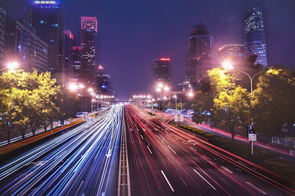 Fotografía time-lapse de coches que pasan por la carretera entre edificios