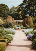 An inviting outdoor space with neatly cut grass, a stone pathway, and bright flowerpots.