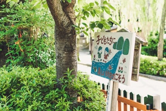A charming cartoon girl playing with a wooden sign that says 'yo soy belab' surrounded by earthy tones and natural elements.