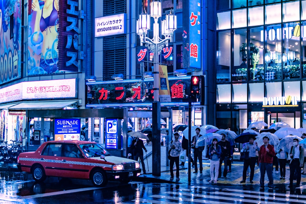 people holding umbrella standing near pedestrian lane