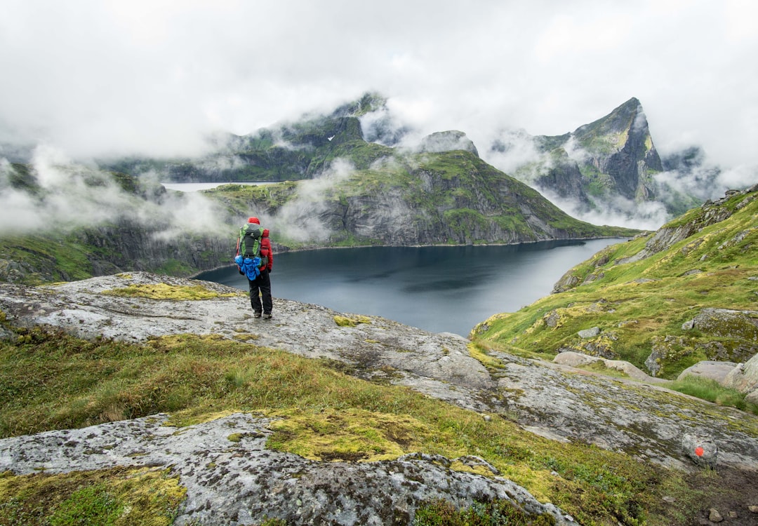 person standing on top of mountain during daytime, Even if the Lofoten mountains don’t even closely reach elevations like their brothers in the Alps, their vastness and power stands out even more. Towering straight out of the ocean they appear wilder and unreachable.</p></figure><p>Only a few hours walk away from the main road wilderness surrounds the handfull of hikers out here.