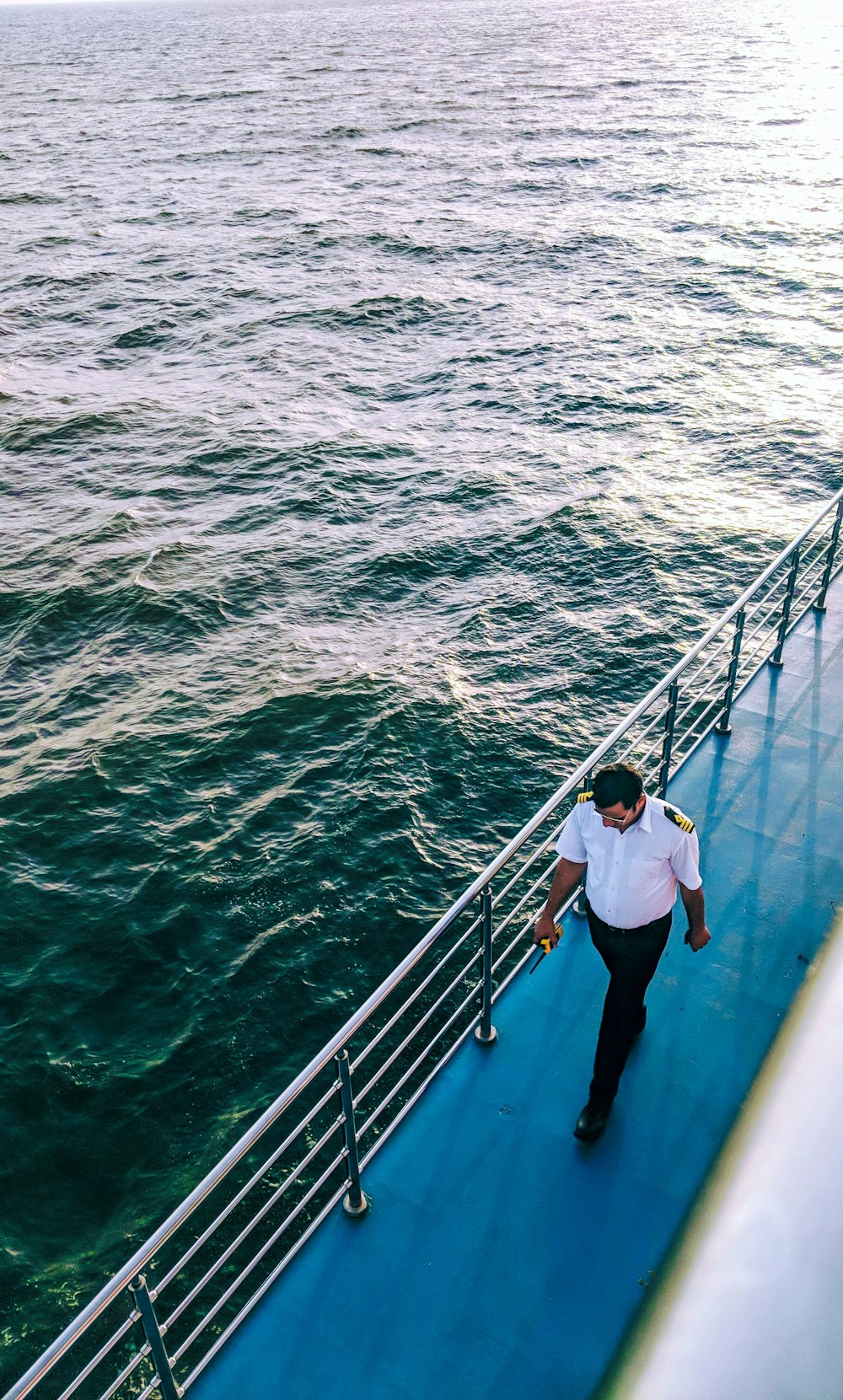 man walking on blue boat surface