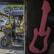 A man in a khaki uniform sits inside a black and yellow auto-rickshaw with an open side door. The vehicle is on a sunny city street, surrounded by other vehicles. In the foreground, part of the interior of another vehicle is visible, with a large pink guitar decal on a black background.