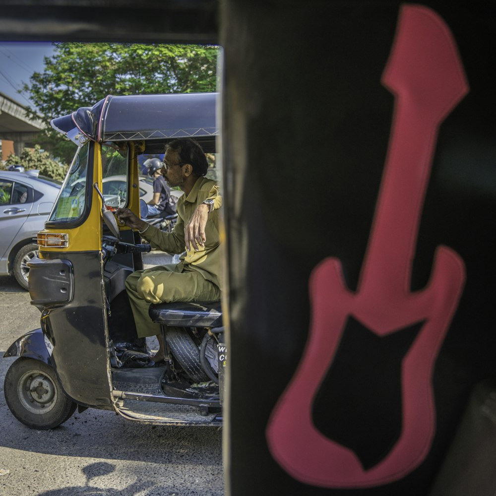 man riding auto rickshaw
