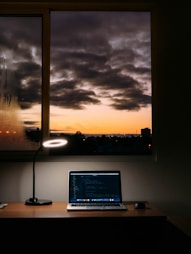 A cozy workspace with a laptop displaying a coding blog in dark mode.