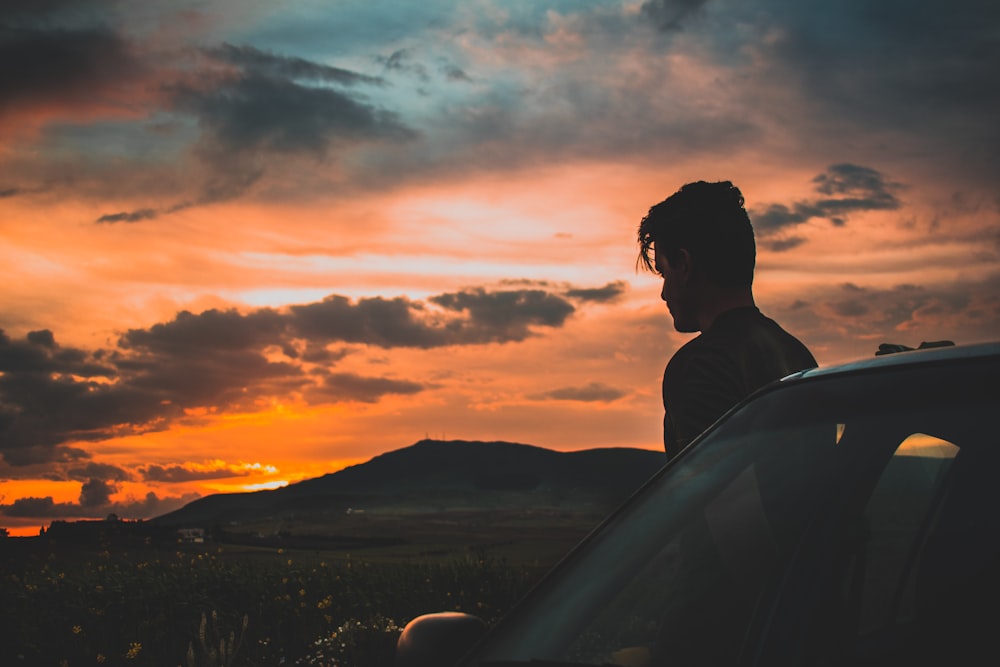 Foto de la silueta del hombre mirando en la puesta del sol