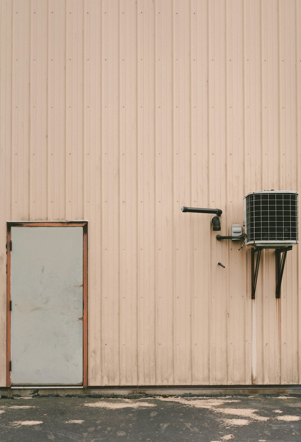 gray air condenser beside gray closed door