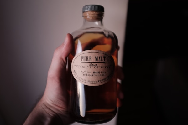Person holding pure malt bottle