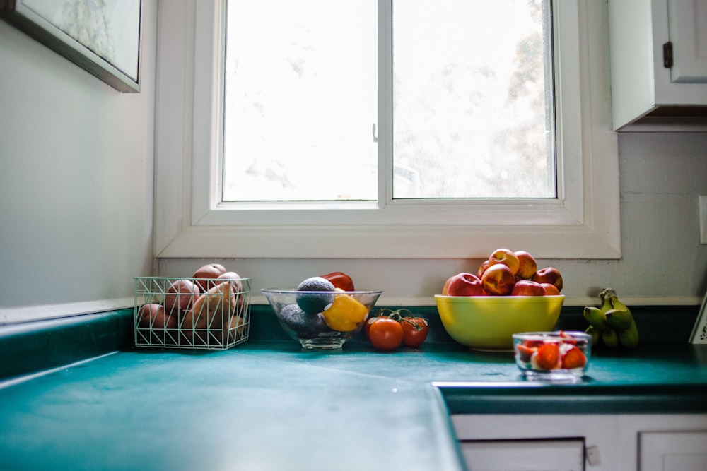 bol de pomme rouge sur armoire de cuisine bleue