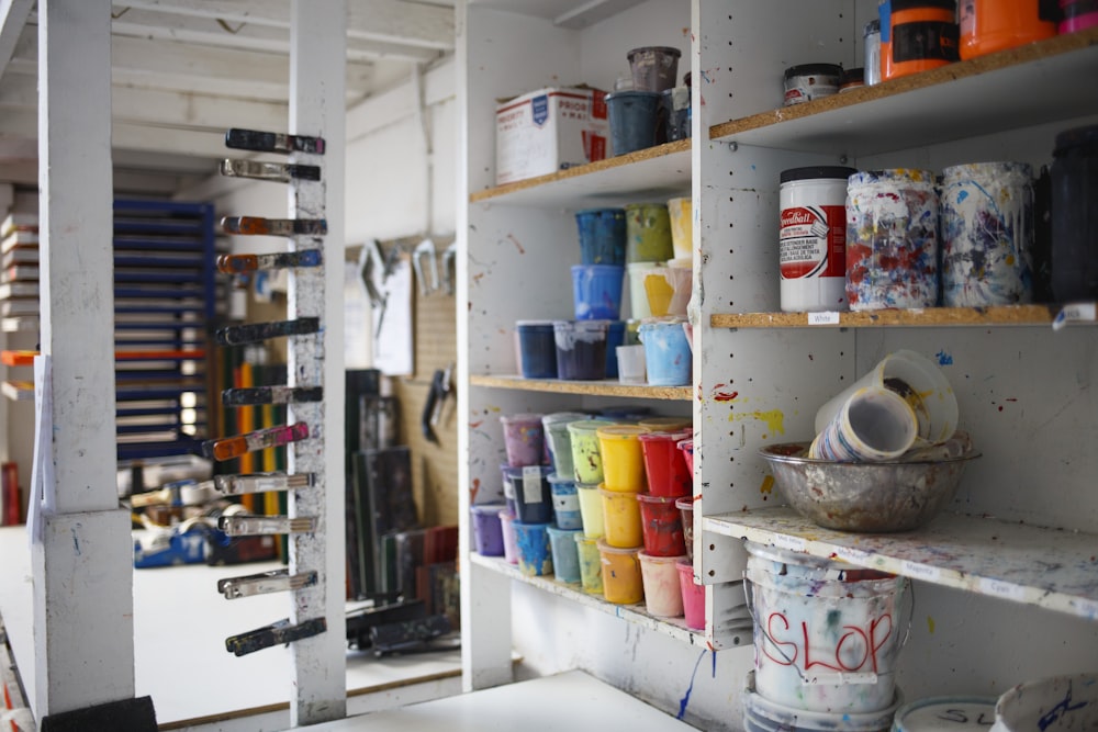 person taking photo of paint containers on display rack