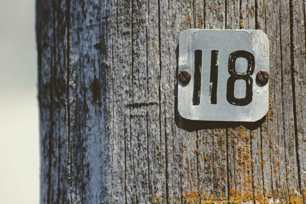 um close up de um número em um poste de madeira