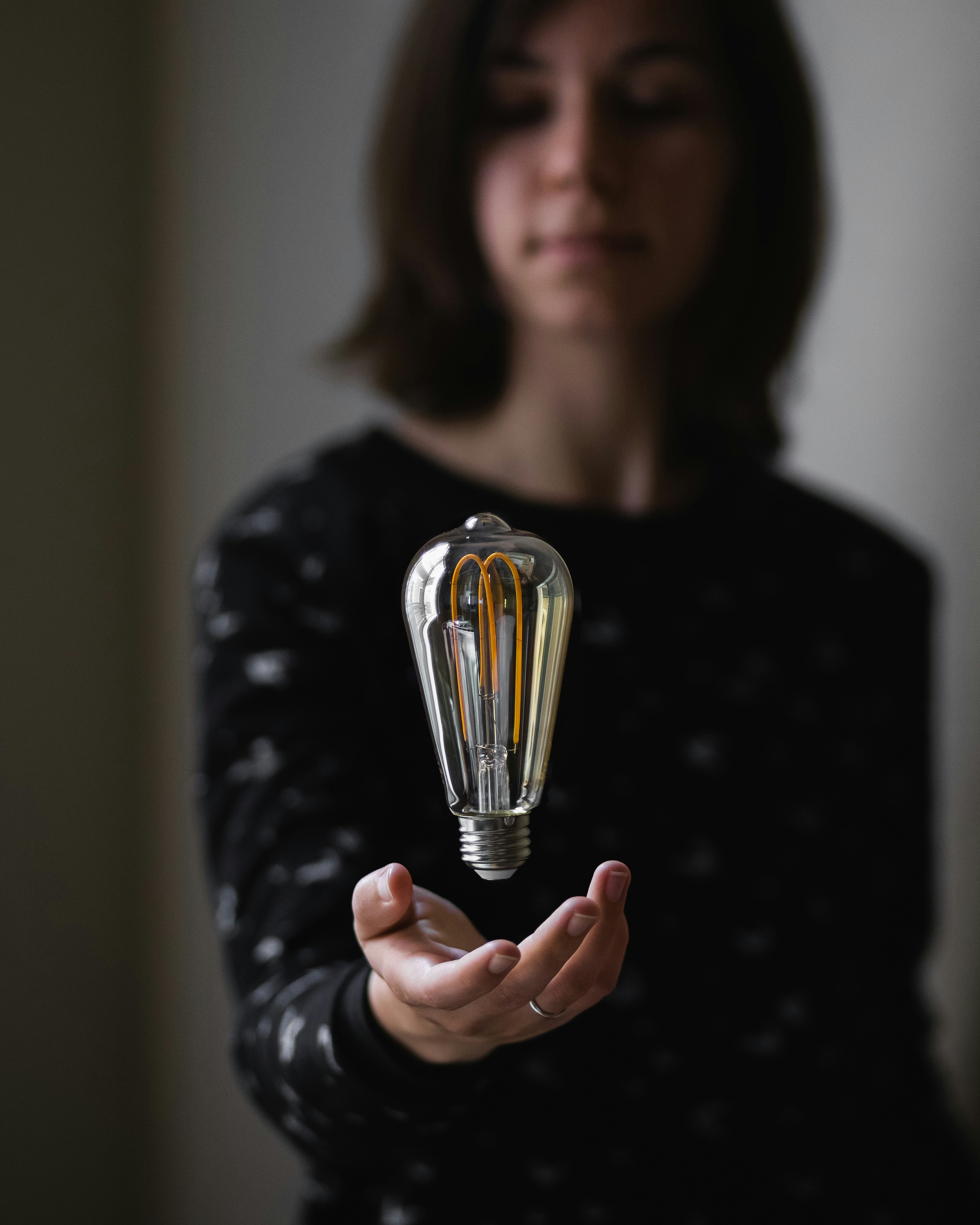 person trying to hold clear light bulb
