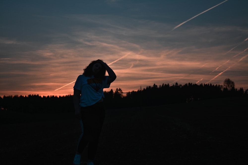 silhouette of woman in front of falling stars at golden hour