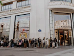 people queuing beside Louis Vuitton store