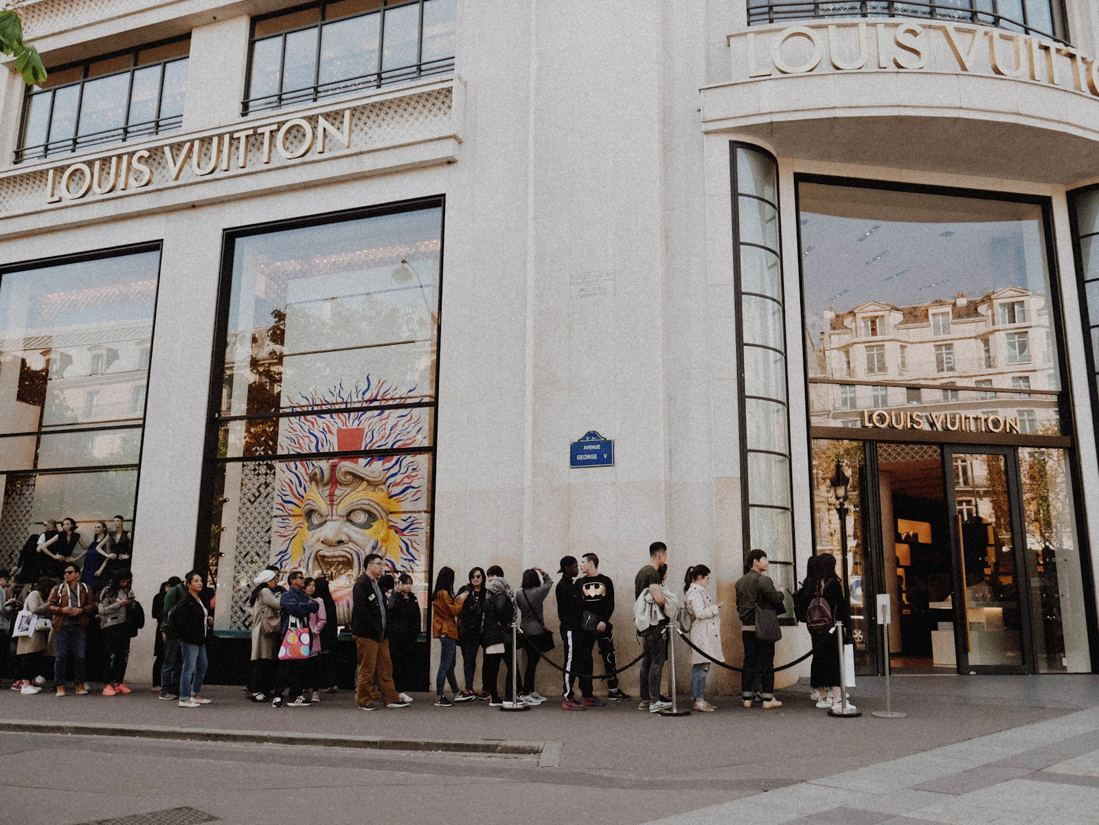 File d'attente de clients devant une boutique de luxe