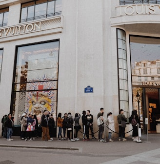 people queuing beside Louis Vuitton store