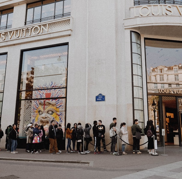 people queuing beside Louis Vuitton store