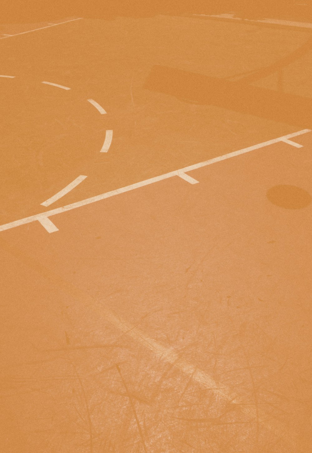 person taking a photo of orange basketball court