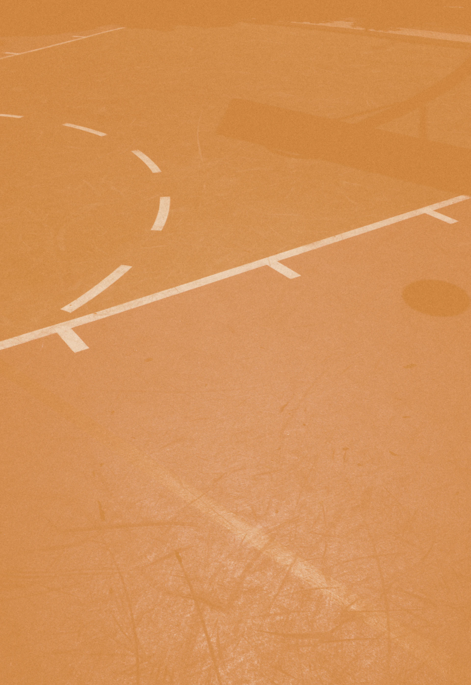 person taking a photo of orange basketball court