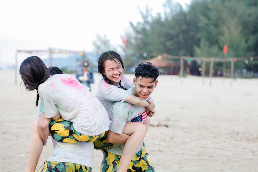 two man carrying girls on seashore