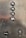 A metallic panel with elevator buttons labeled P6, P4, P2, and GAL in a vertical alignment. Below the buttons, there is a black button labeled ALARM and a keyhole labeled as FIREMANS SERVICE.