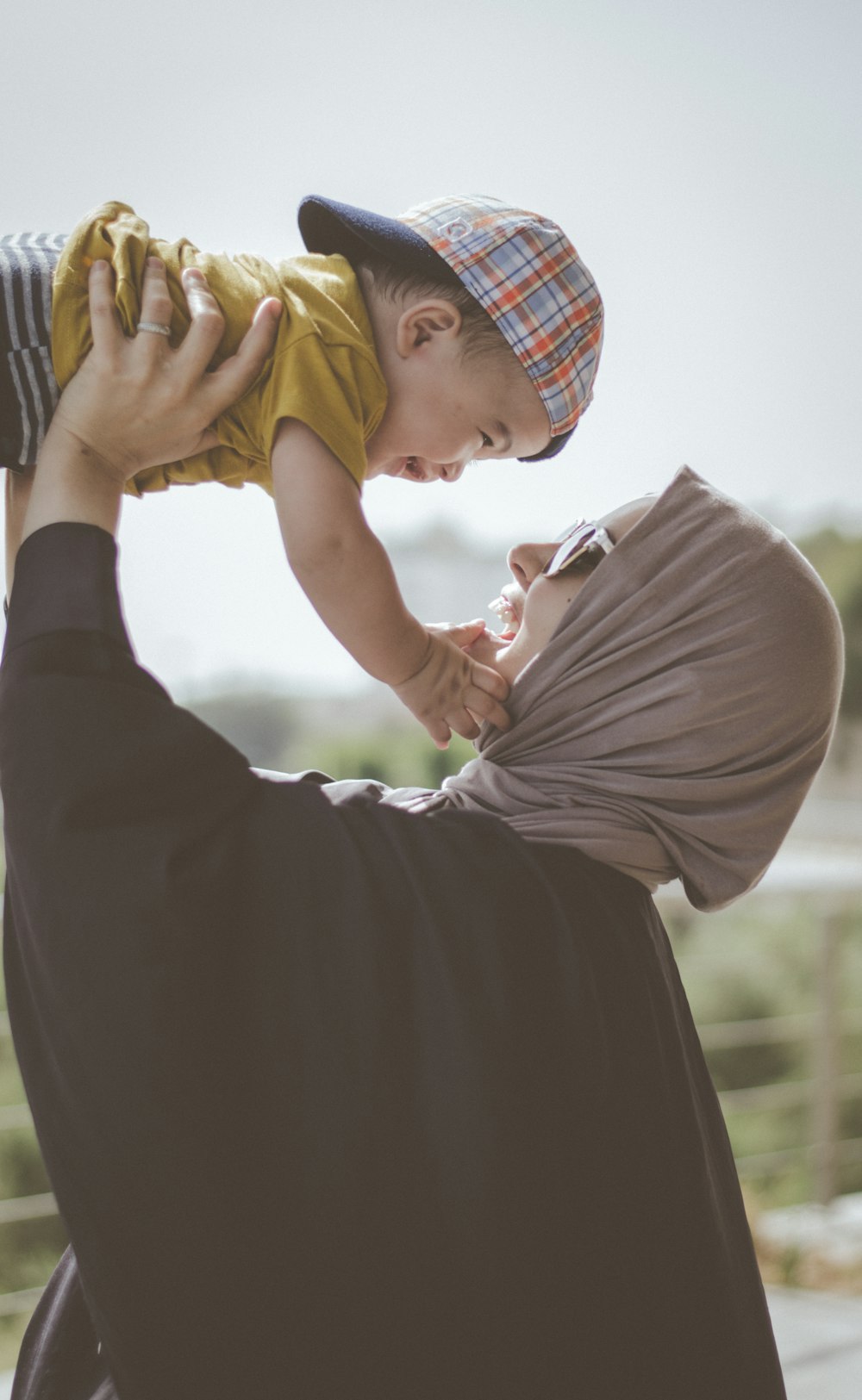 woman holding boy during daytime