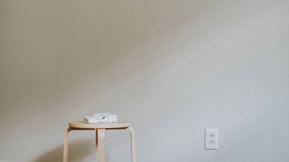 round brown wooden stool near outlet