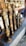Several intricately designed musical instruments with ornate golden and bronze detailing are arranged on a stone shelf. Behind the instruments, there are reflections and glimpses of other metallic items, possibly more instruments or decorative objects.